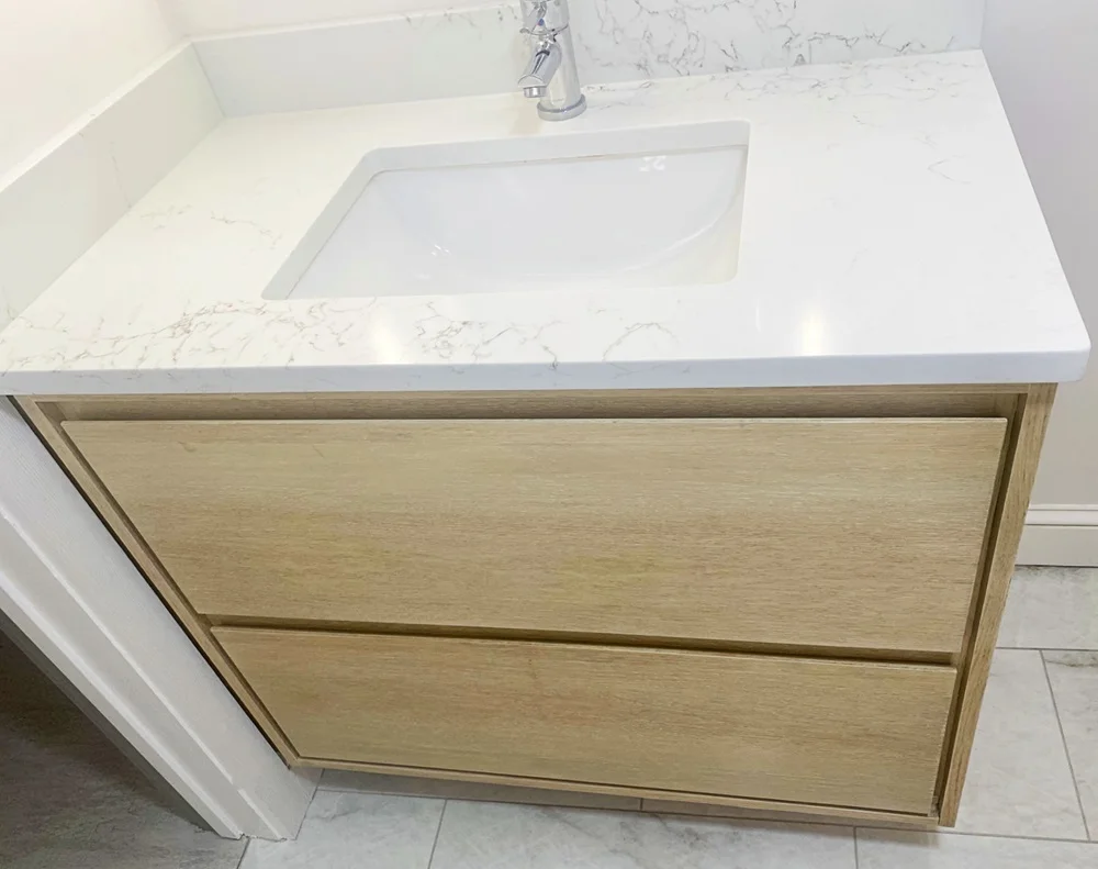 Floating bathroom sink vanity in oak with custom layout for plumbing.  Interior drawers in maple.